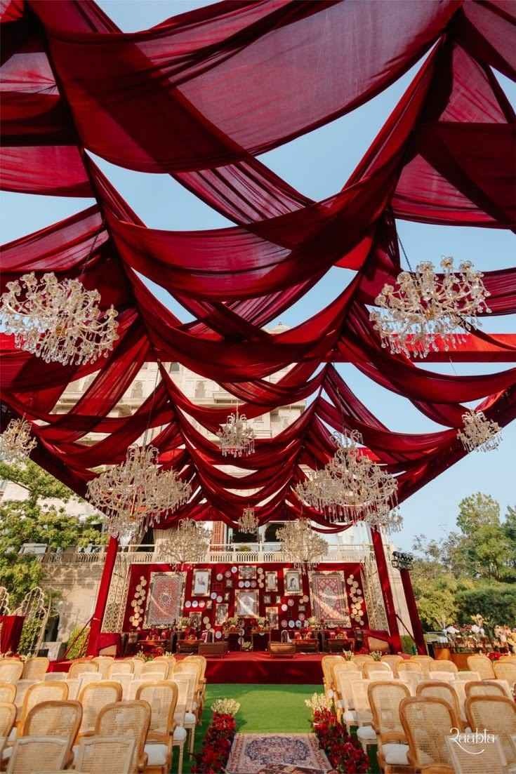 Red canopy wedding stage with crystal chandeliers in Delhi NCR.