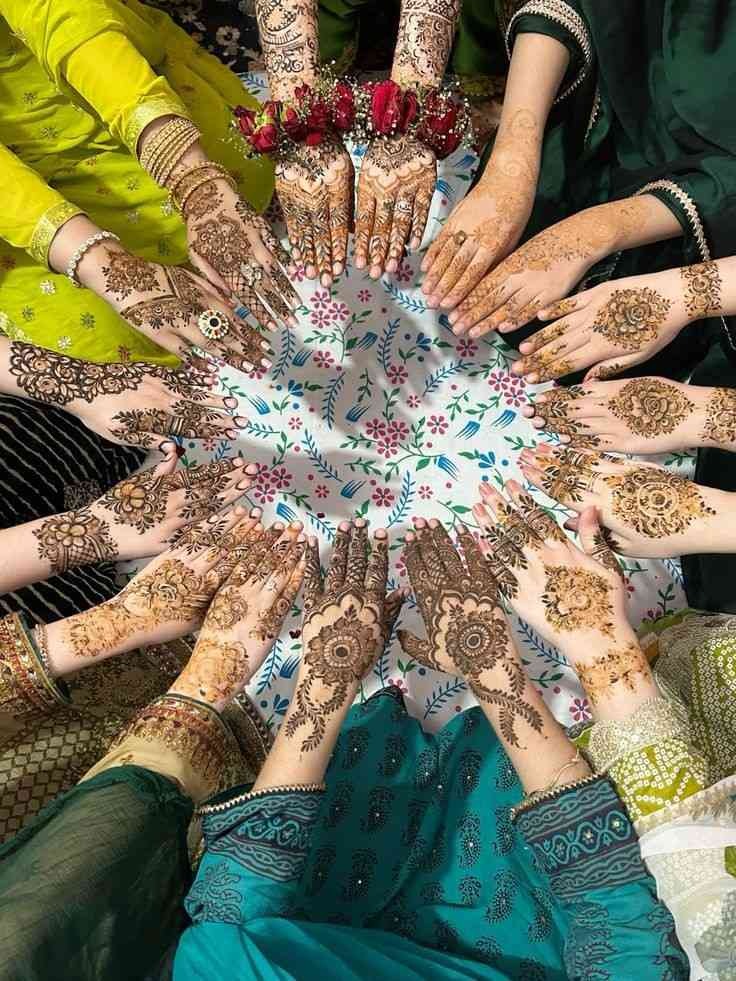 Beautiful group mehndi designs on women’s hands during wedding mehendi function featuring intricate bridal henna patterns and traditional festive celebration.