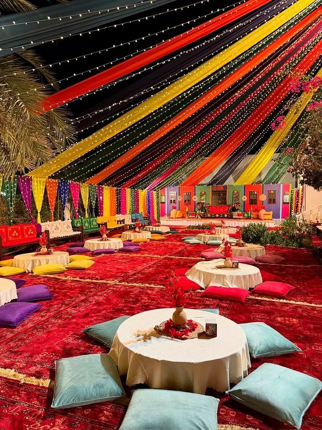Colorful mehendi and sangeet ceremony decoration setup with traditional seating, vibrant drapes, fairy lights, and luxury wedding event décor in Delhi NCR.