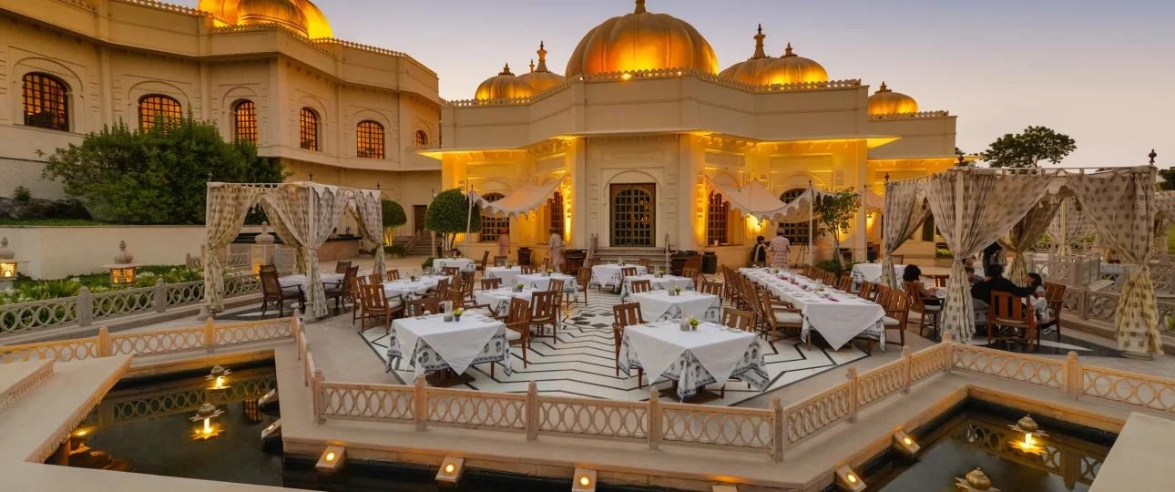 Luxury outdoor wedding venue with royal palace architecture, elegant dining setup, and illuminated domes for grand destination weddings in India.
