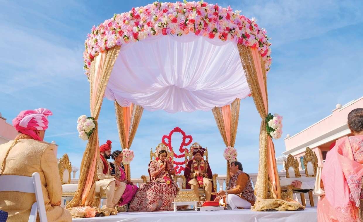 Traditional Hindu wedding ceremony under a floral mandap.