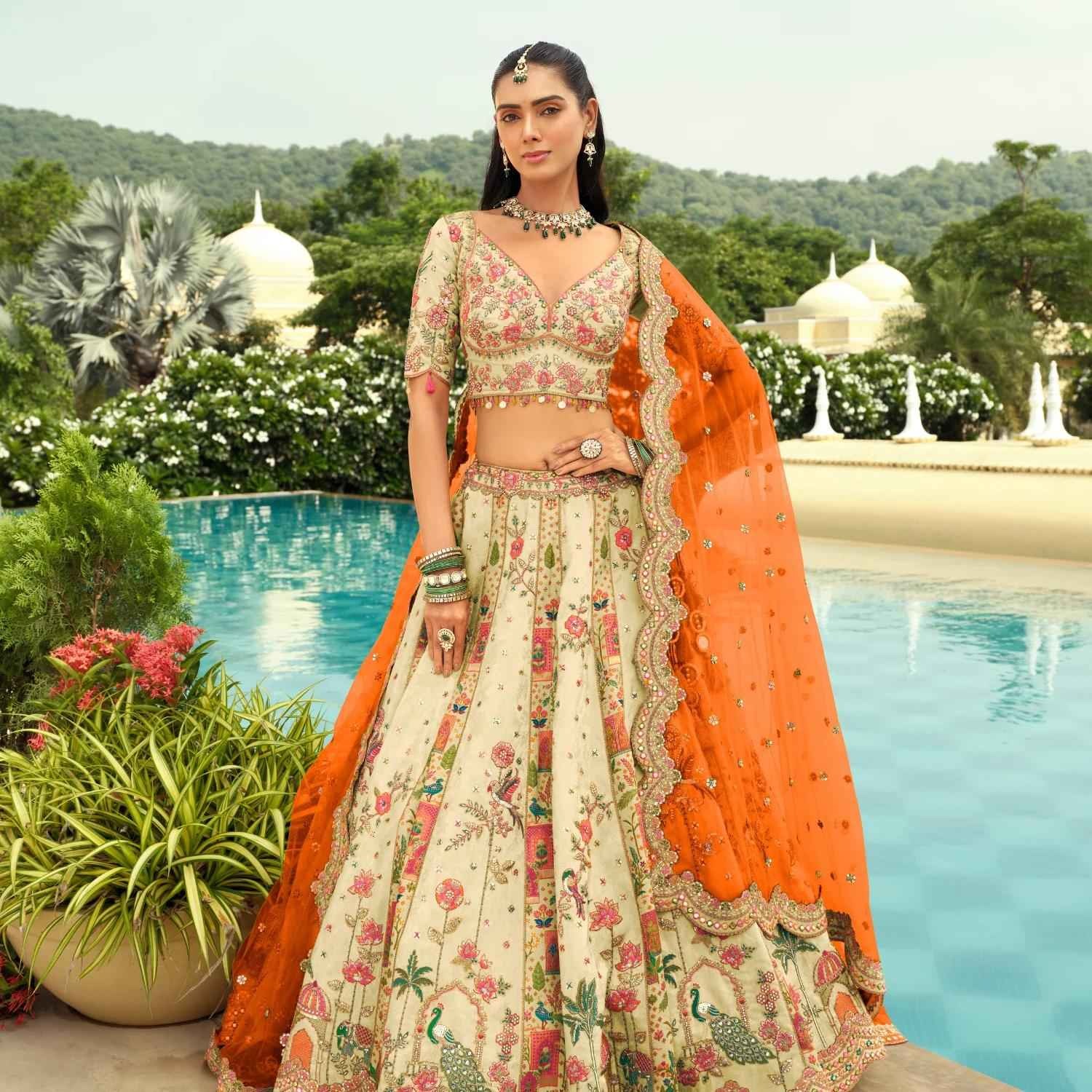 Lehenga for bride with floral embroidery and vibrant orange dupatta, perfect for destination and daytime weddings.