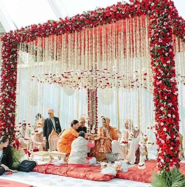 Elegant red floral wedding mandap with hanging garlands
