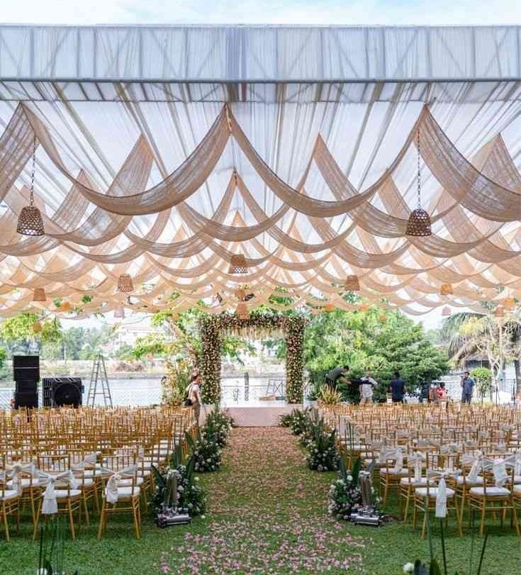 Outdoor garden wedding setup with draped canopy