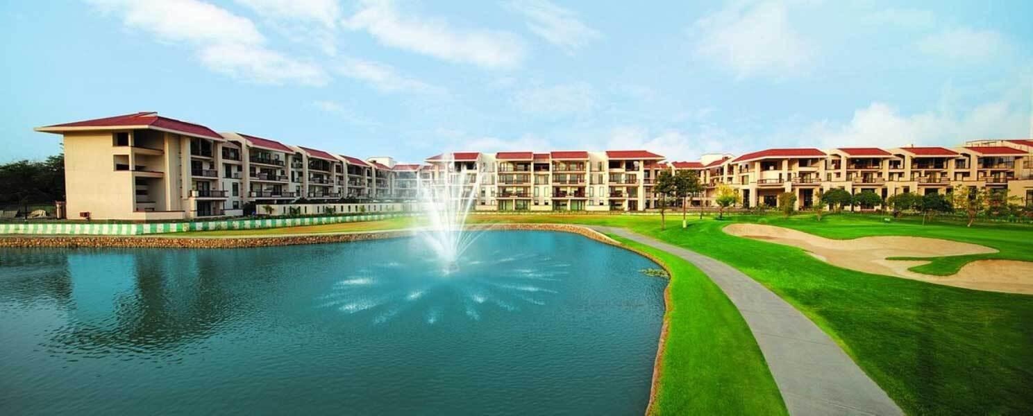 "Premium lakeside resort and residential complex with fountain, landscaped gardens, luxury apartments, and scenic outdoor views."