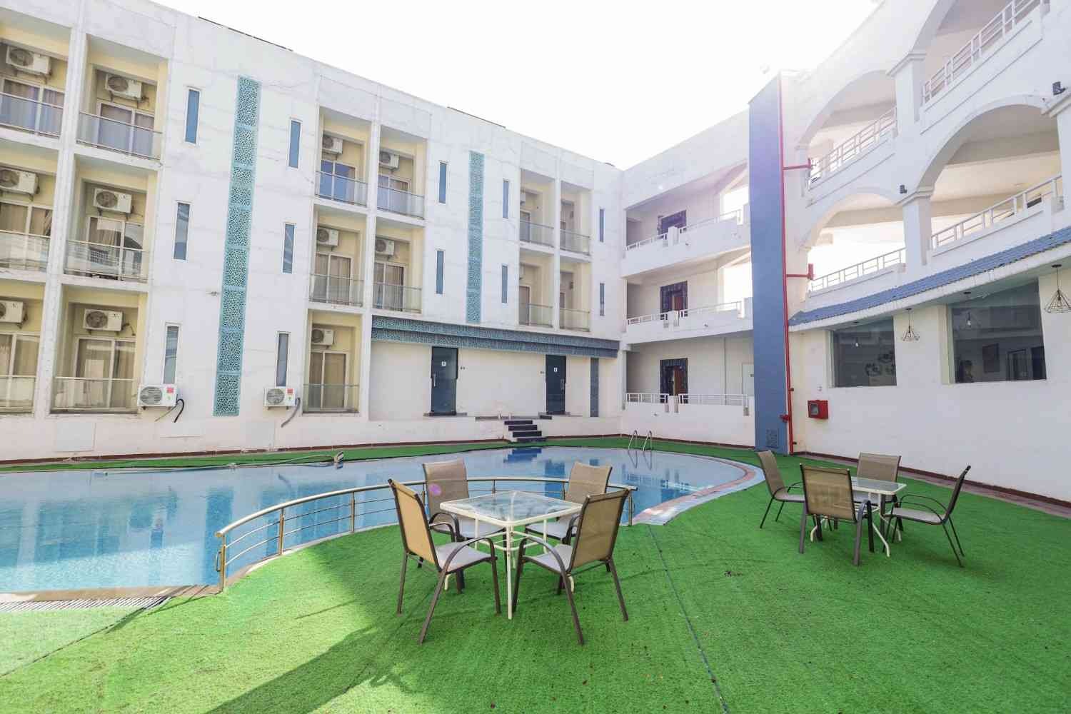 Modern resort with illuminated swimming pool and premium guest rooms at dusk
