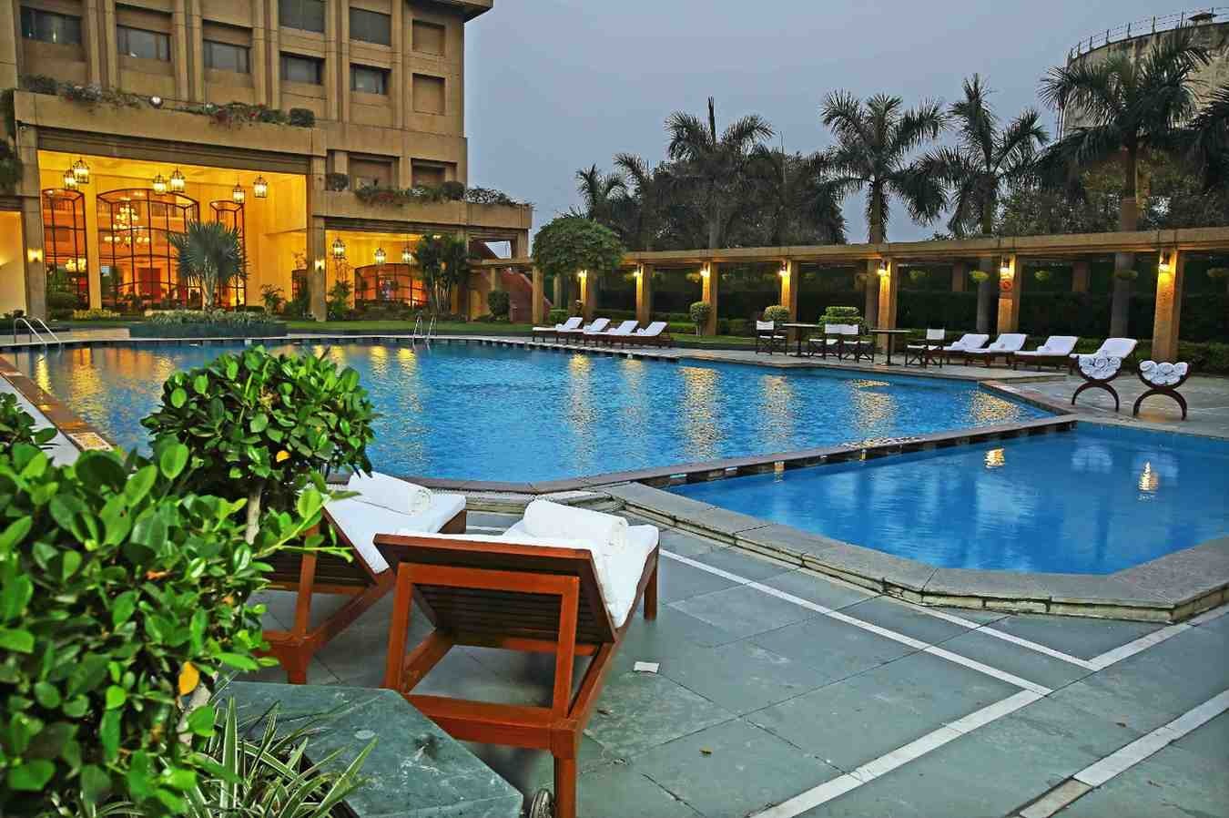 Luxury outdoor swimming pool at Eros Hotel Nehru Place Delhi with poolside loungers and landscaped garden