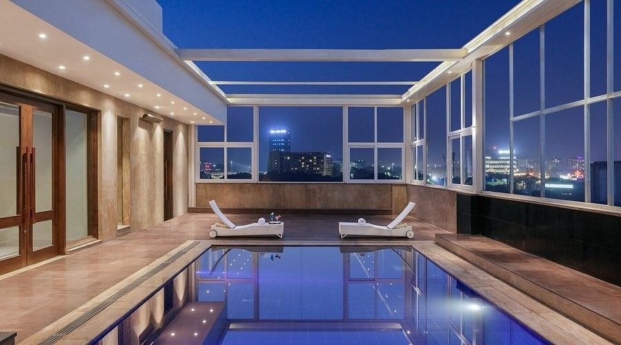 Modern indoor swimming pool at Golden Tulip Sector 29 Gurgaon with city skyline views