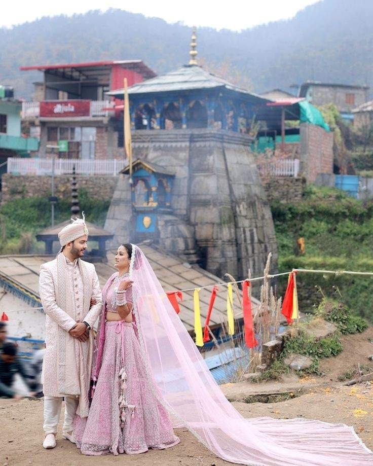 Bride and groom in traditional wedding attire posing at a scenic temple for a destination wedding photoshoot.