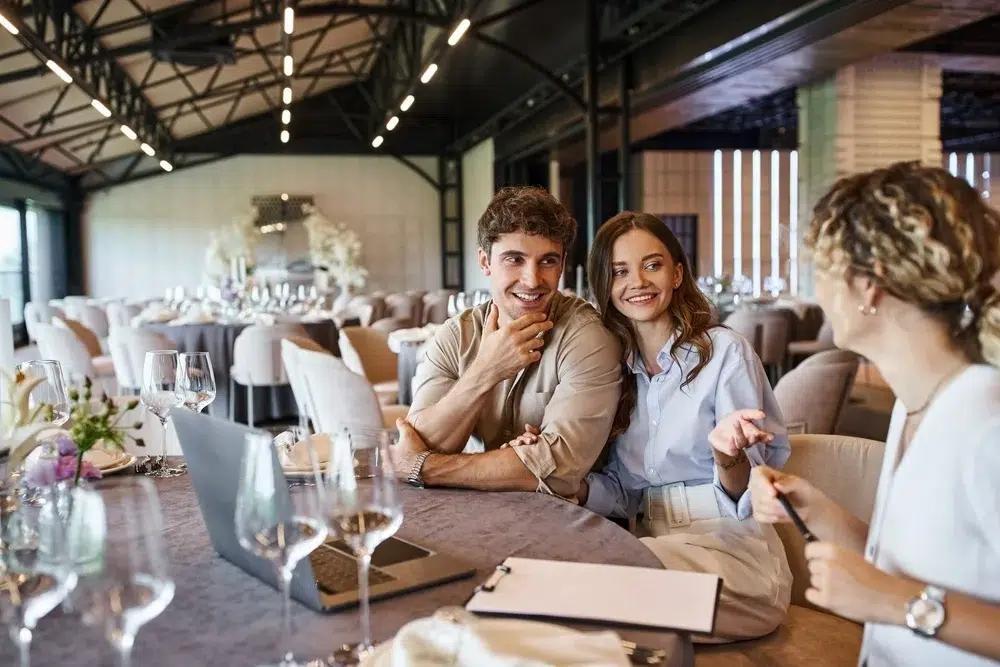 Couple touring a premium banquet hall with a venue booking consultant before their wedding event.