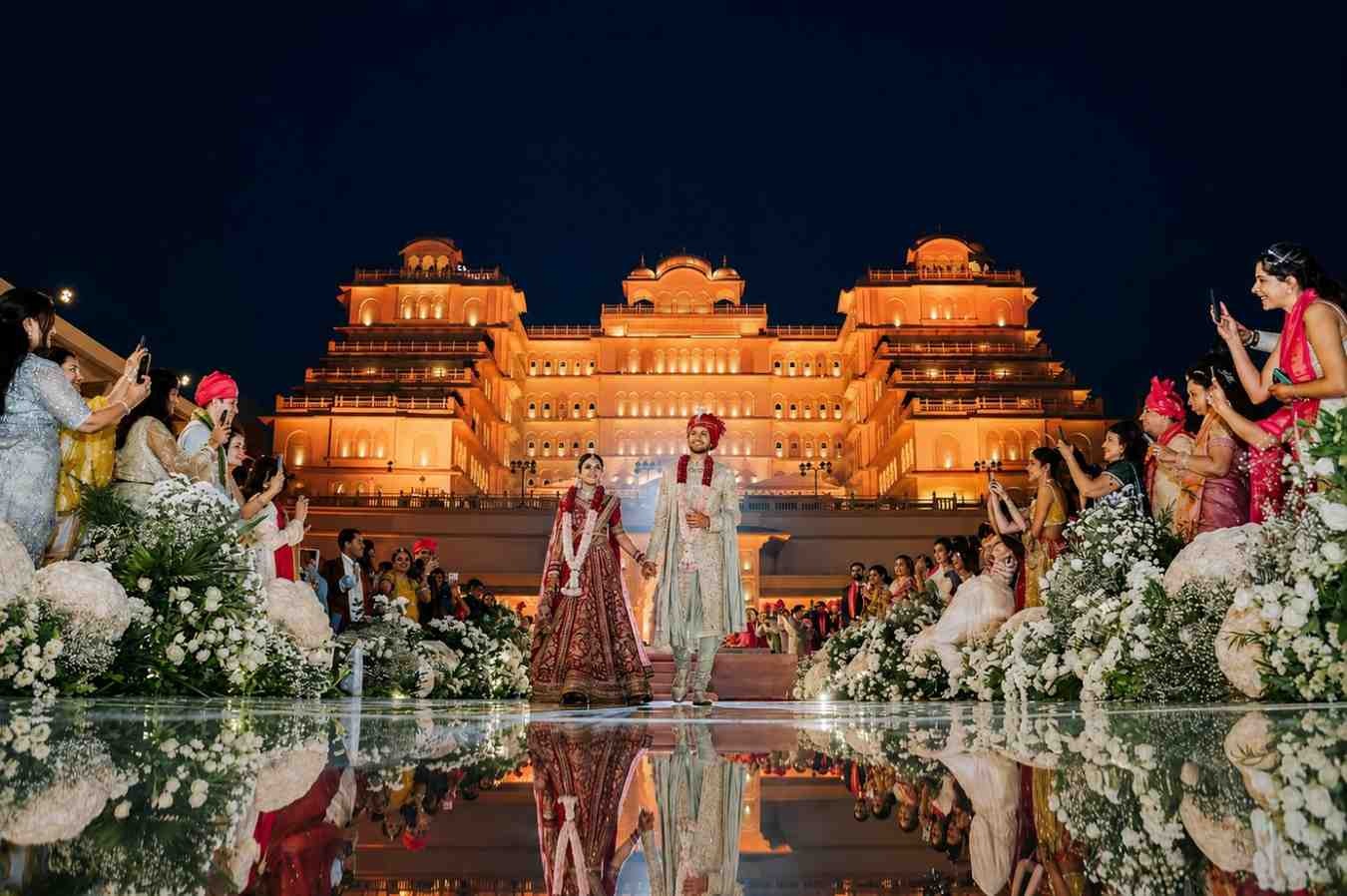 Luxury palace wedding venue with bride and groom grand entry during a royal destination wedding celebration in India.