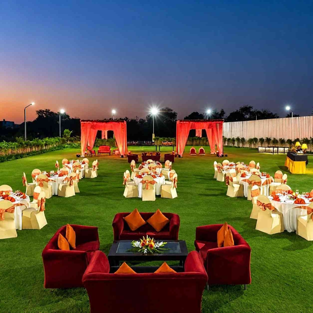 Elegant outdoor wedding lawn with banquet seating and evening decor.